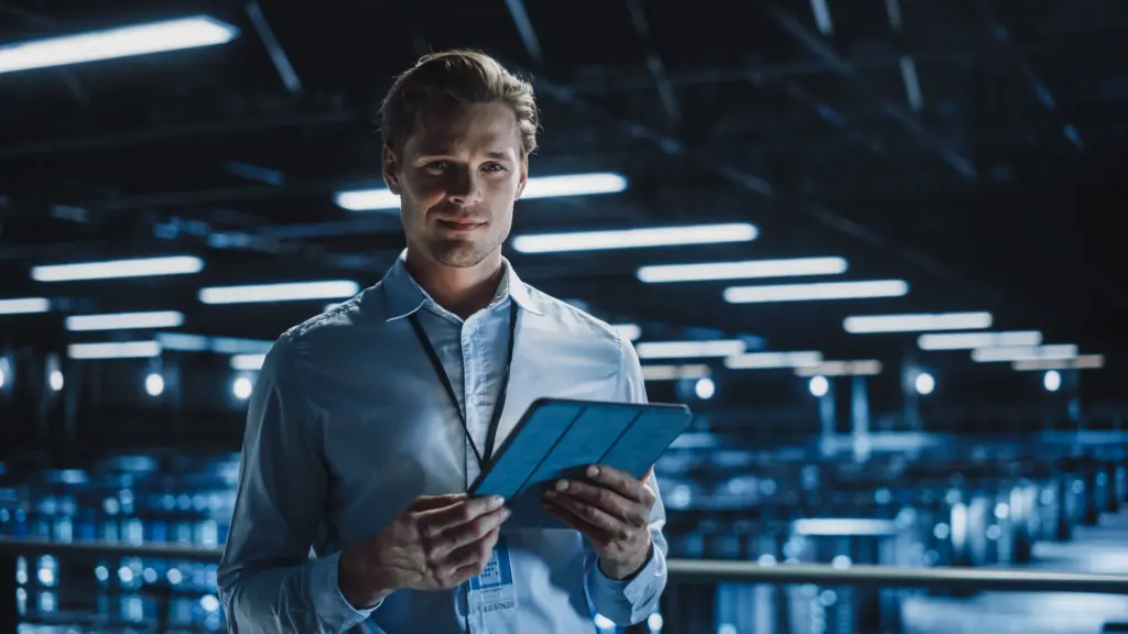 IT-Experte mit Tablet in einem modernen Rechenzentrum überwacht die IT-Infrastruktur